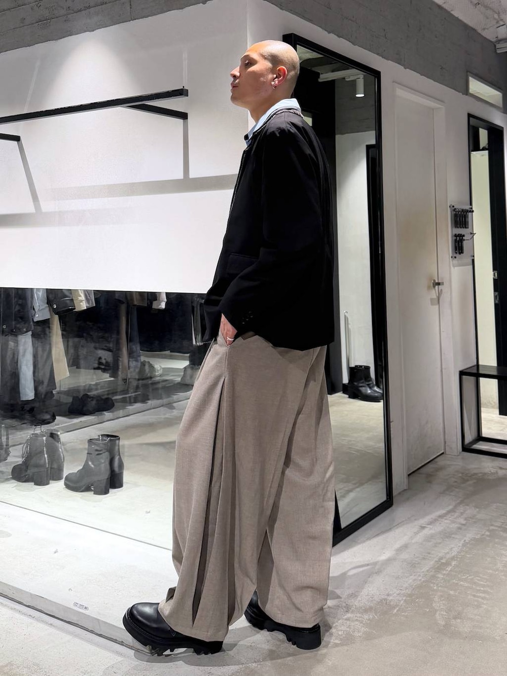 ブラック系のドレスシューズ、ブラック系のトートバッグ、ブラック系のテーラードジャケットを着用したメンズの冬コーディネートの2枚目の写真