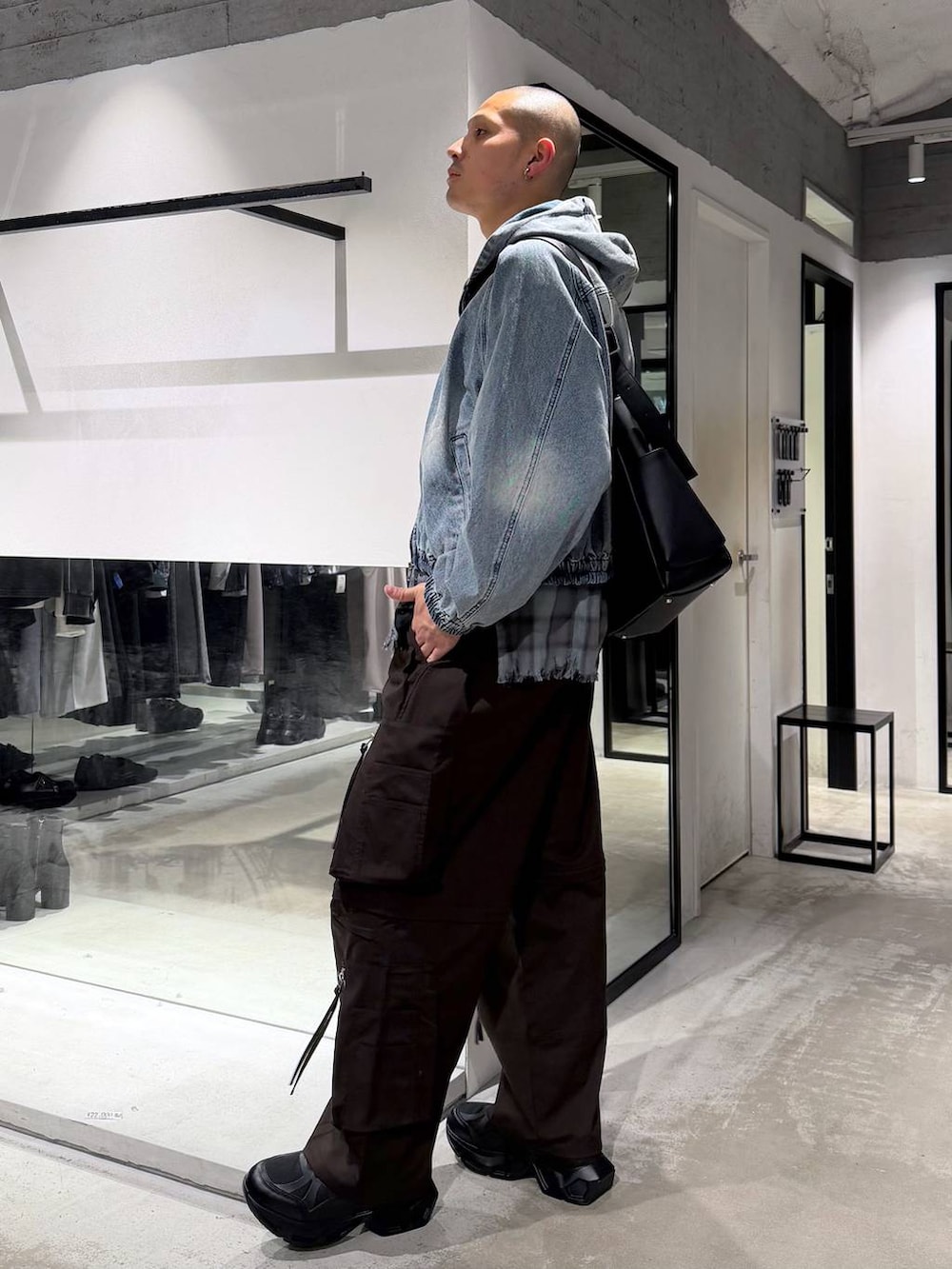 ブラック系のスニーカー、ブルー系のブルゾン、ブラウン系のカーゴパンツを着用したメンズの春コーディネートの2枚目の写真