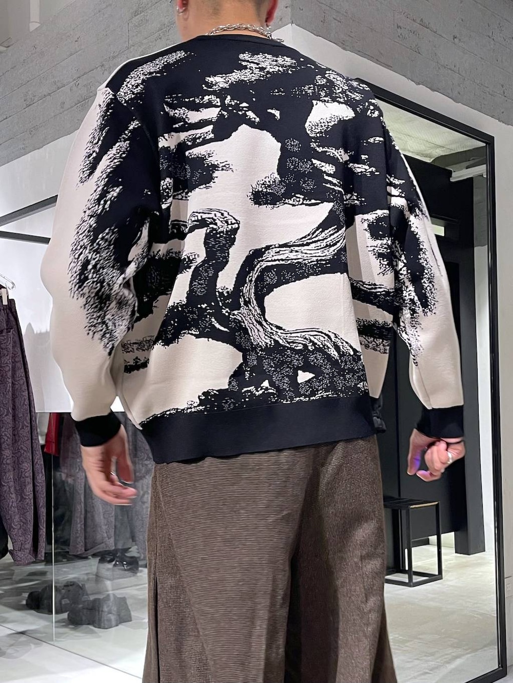 ブラウン系のスラックス、ブラック系のダウンジャケット/コート、ブラック系のドレスシューズを着用したメンズの冬コーディネートの6枚目の写真