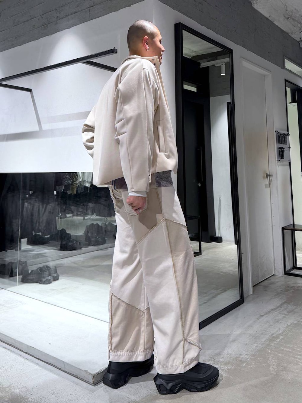 グレー系のカーディガン/ボレロ、ブラック系のブーツ、ホワイト系のブルゾンを着用したメンズの冬コーディネートの4枚目の写真