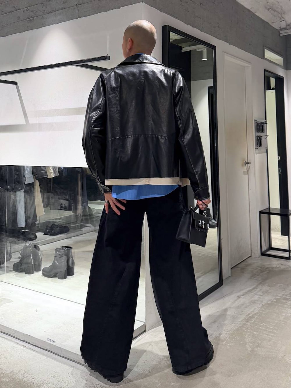 ブルー系のシャツ/ブラウス、ブラック系のドレスシューズ、ブラック系のハンドバッグを着用したメンズの冬コーディネートの3枚目の写真