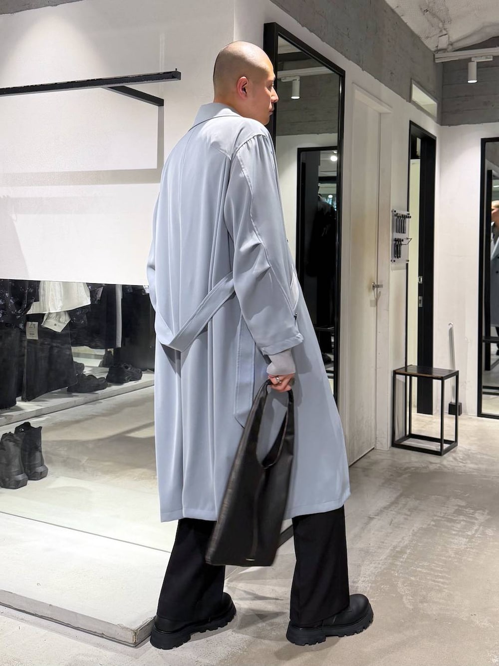 ブラック系のトートバッグ、ブラック系のスラックス、ブラック系のドレスシューズを着用したメンズの春コーディネートの4枚目の写真