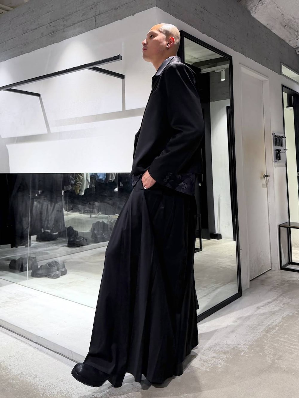 ブラック系のトートバッグ、ブラック系のその他パンツ、ブラック系のブーツを着用したメンズの冬コーディネートの2枚目の写真