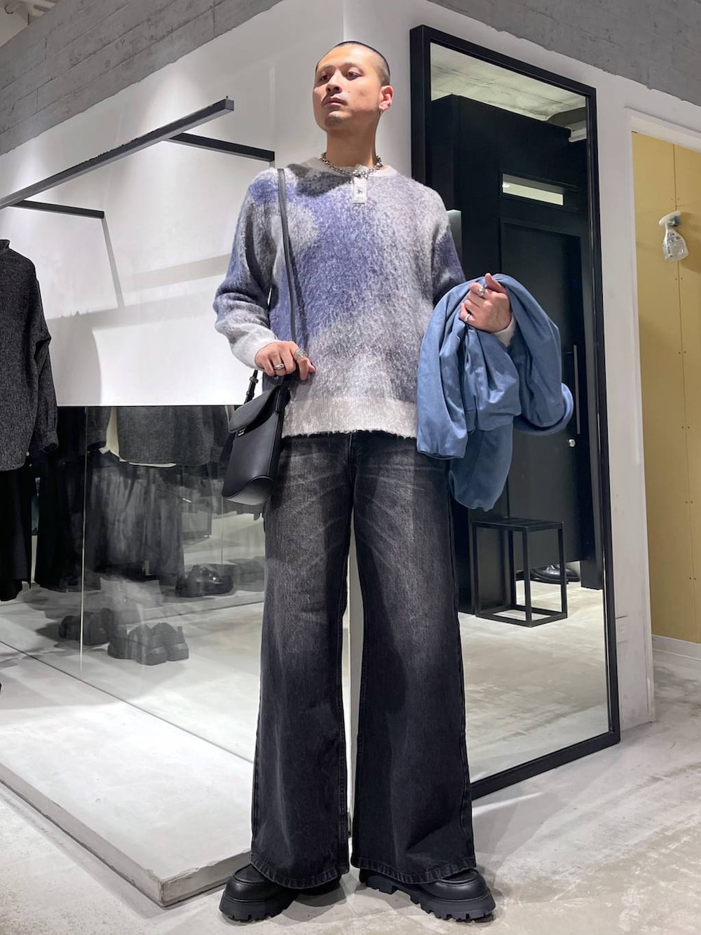 ブラック系のデニムパンツ、ブラック系のドレスシューズ、ブラック系のショルダーバッグを着用したメンズの冬コーディネートの5枚目の写真