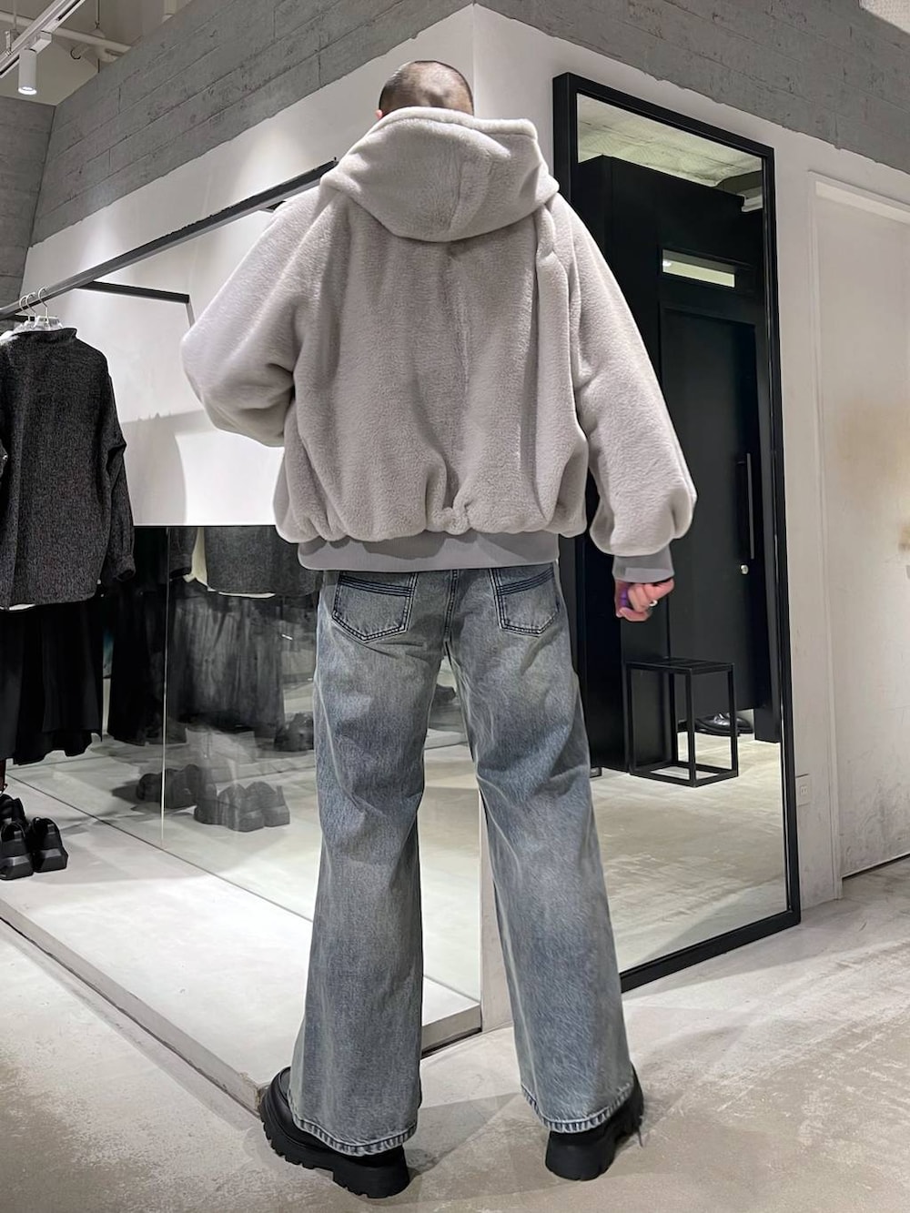 グレー系のブルゾン、ブルー系のデニムパンツ、ブラック系のドレスシューズを着用したメンズの冬コーディネートの3枚目の写真