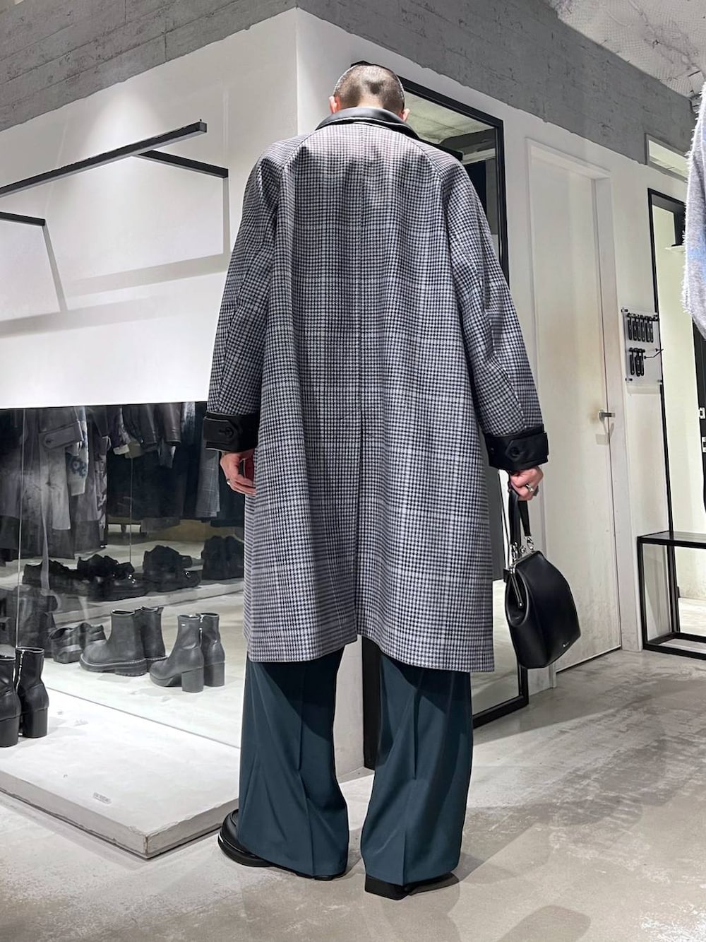 ホワイト系のネクタイ、ベージュ系のステンカラーコート、ブラック系のショルダーバッグを着用したメンズの秋コーディネートの4枚目の写真