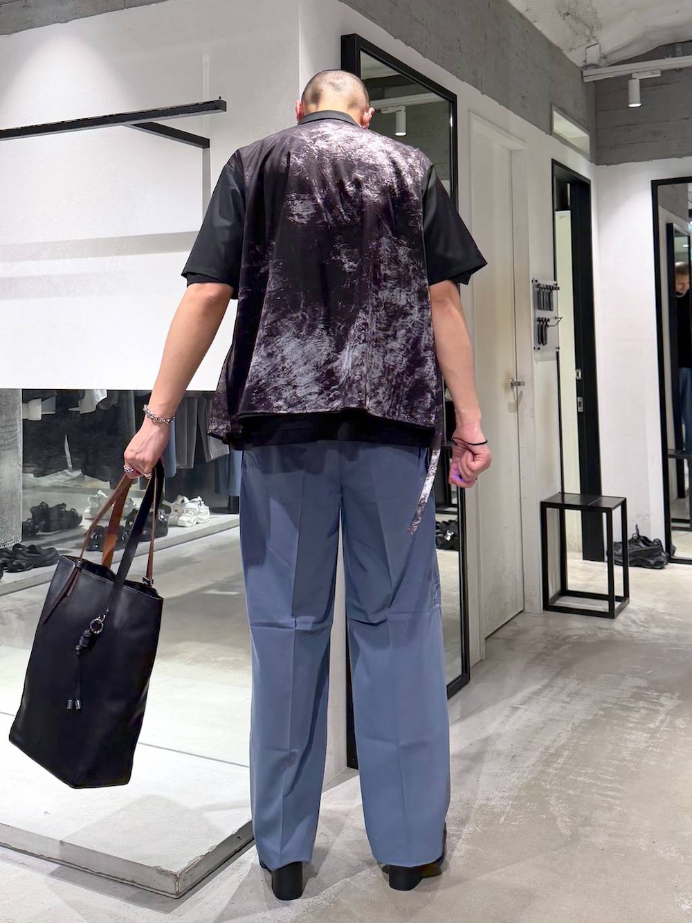 ブラック系のTシャツ/カットソー、ブラック系のサンダル、ブルー系のスラックスを着用したメンズの春コーディネートの3枚目の写真