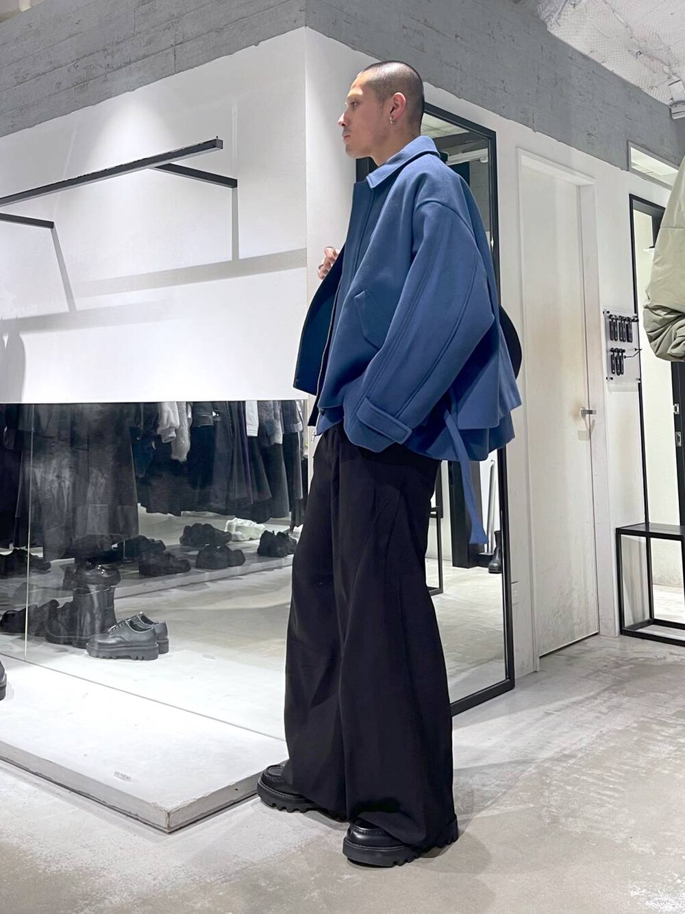 ブルー系のブルゾン、ブラック系のスラックス、ブラック系のショルダーバッグを着用したメンズの秋コーディネートの2枚目の写真