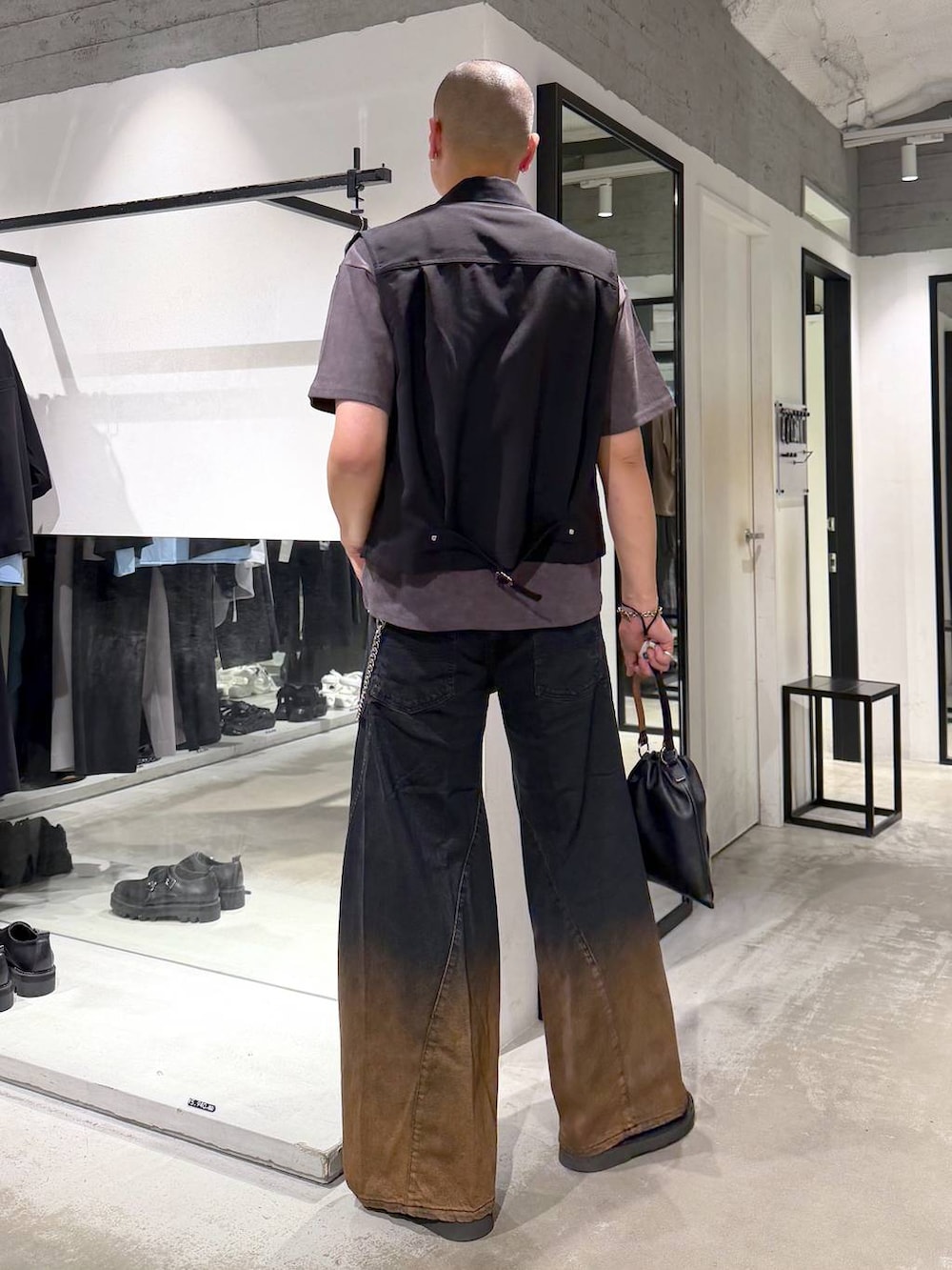 オレンジ系のデニムパンツ、ブラック系のサンダル、ブラック系のショルダーバッグを着用したメンズの夏コーディネートの3枚目の写真