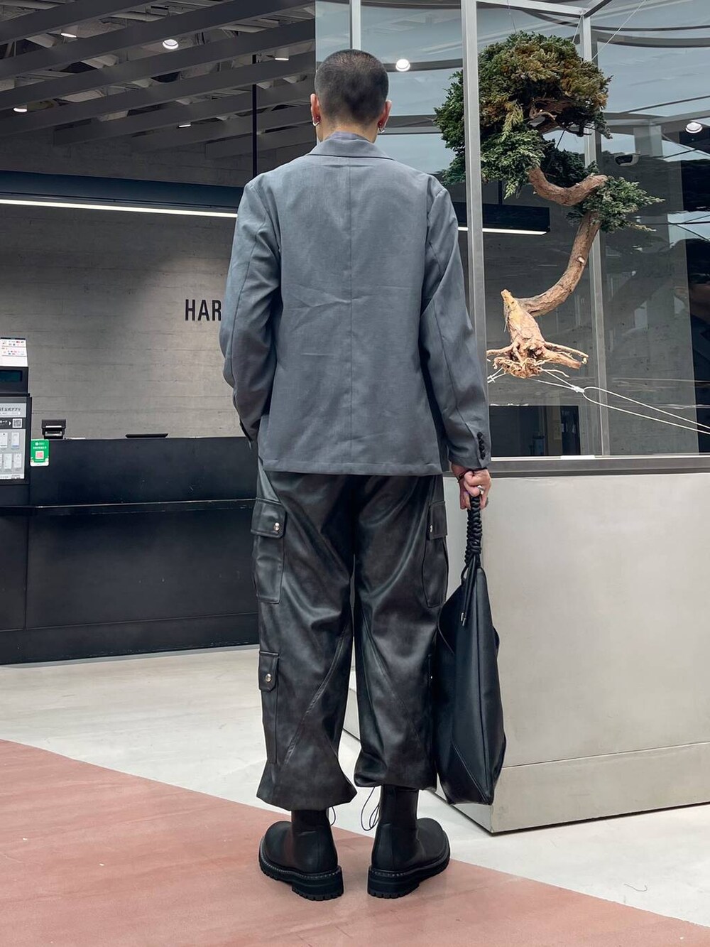 グレー系のカーゴパンツ、グレー系のテーラードジャケット、ブラック系のブーツを着用したメンズの秋コーディネートの3枚目の写真