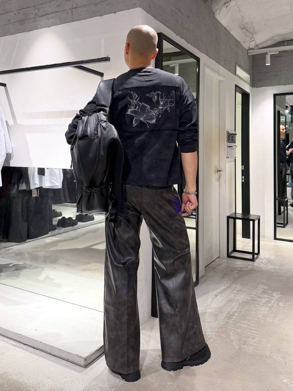 ブラック系のローファー、ブラック系のバックパック/リュック、ブラック系のTシャツ/カットソーを着用したメンズの秋コーディネートの3枚目の写真