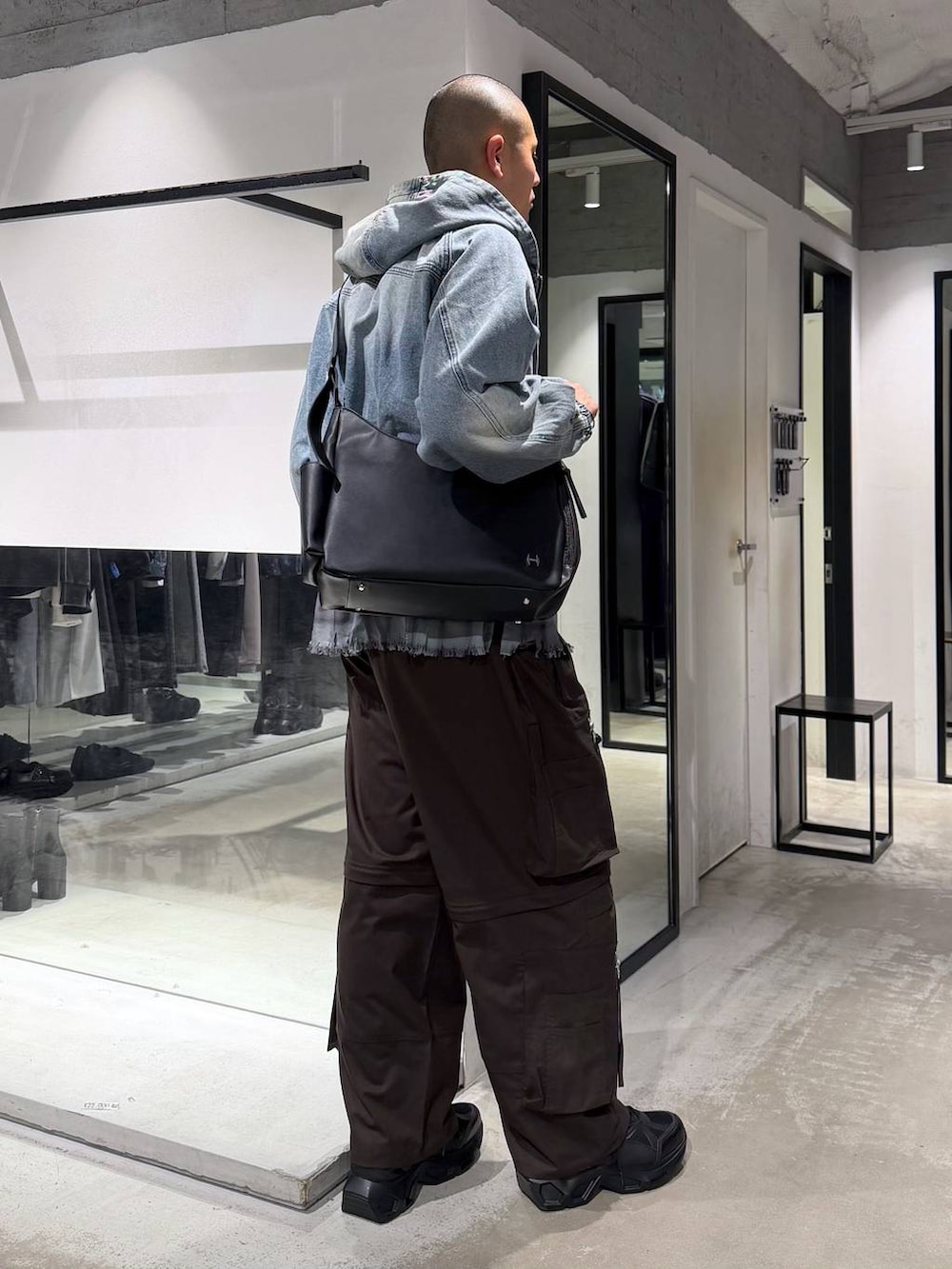 ブラック系のスニーカー、ブルー系のブルゾン、ブラウン系のカーゴパンツを着用したメンズの春コーディネートの4枚目の写真