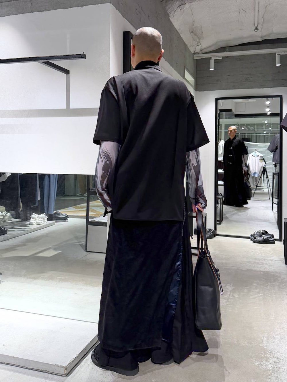 ブラック系のサンダル、ブラック系のトートバッグ、ブラック系のスラックスを着用したメンズの春コーディネートの4枚目の写真