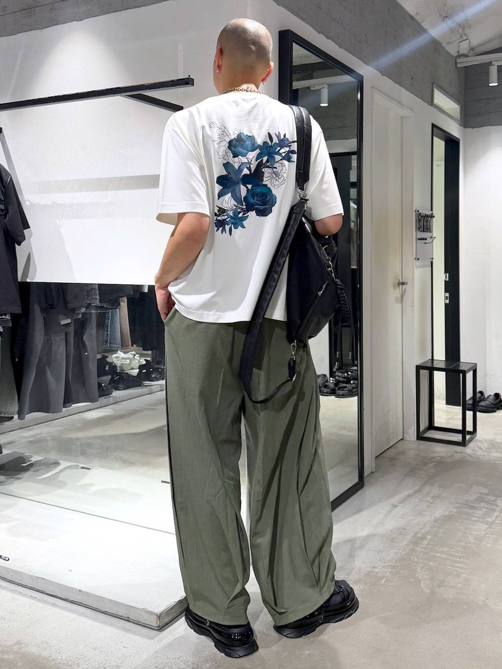 ブラック系のサンダル、グリーン系のスラックス、ホワイト系のTシャツ/カットソーを着用したメンズの夏コーディネートの3枚目の写真