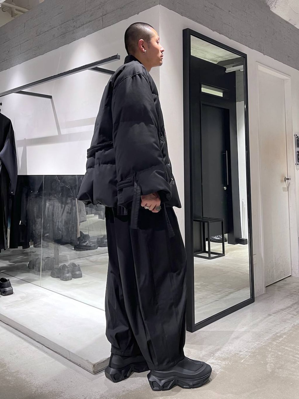 グレー系のカーディガン/ボレロ、ブラック系のダウンジャケット/コート、ブラック系のブーツを着用したメンズの冬コーディネートの4枚目の写真