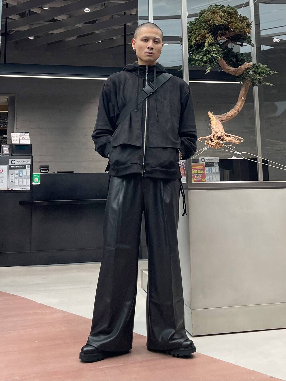 ブラック系のスラックス、ブラック系のメッセンジャーバッグ、ブラック系のドレスシューズを着用したメンズの秋コーディネートの2枚目の写真