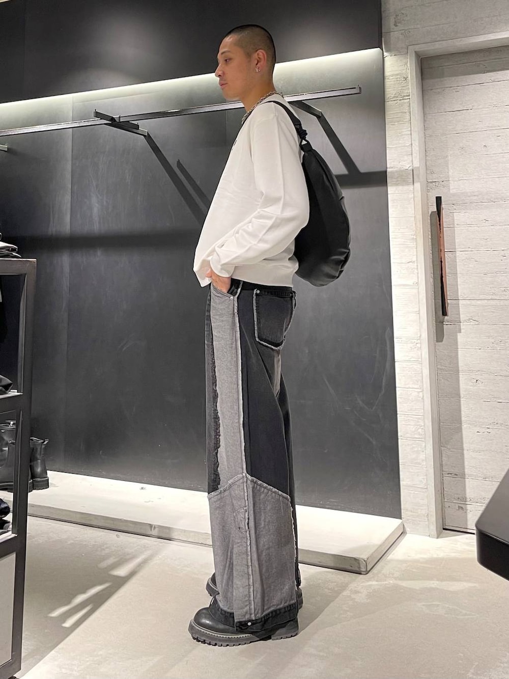 ブラック系のブーツ、ブラック系のショルダーバッグ、シルバー系のネックレスを着用したメンズの秋コーディネートの2枚目の写真