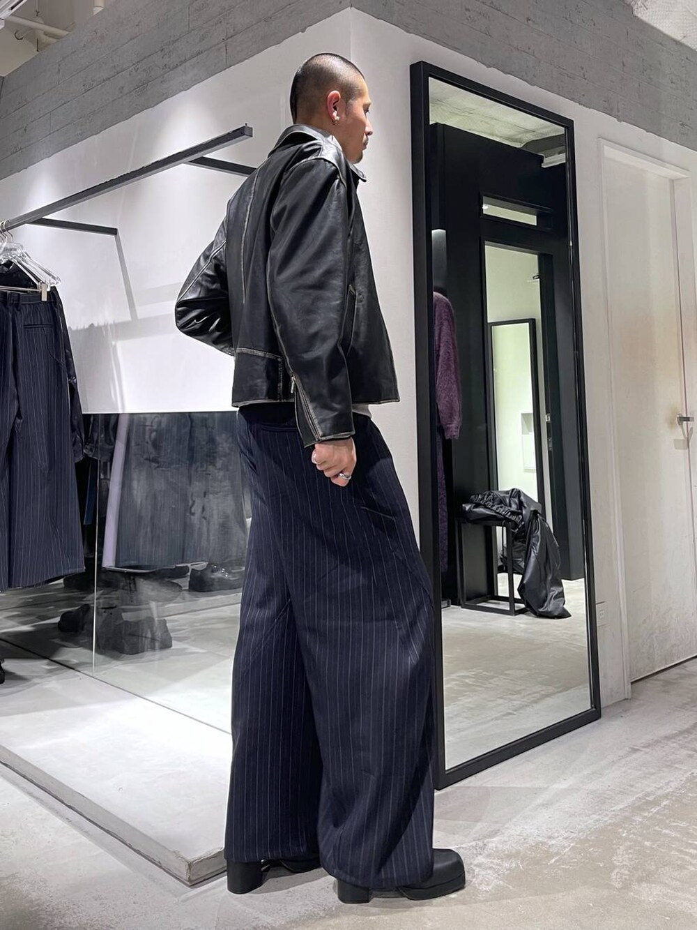 ブルー系のスラックス、ブラック系のブルゾン、ブラック系のブーツを着用したメンズの冬コーディネートの4枚目の写真