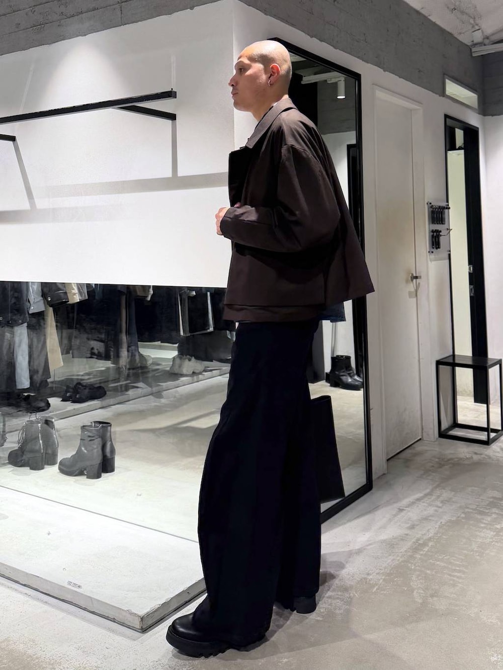 ブラック系のデニムパンツ、ブラック系のドレスシューズ、ブラック系のトートバッグを着用したメンズの冬コーディネートの2枚目の写真