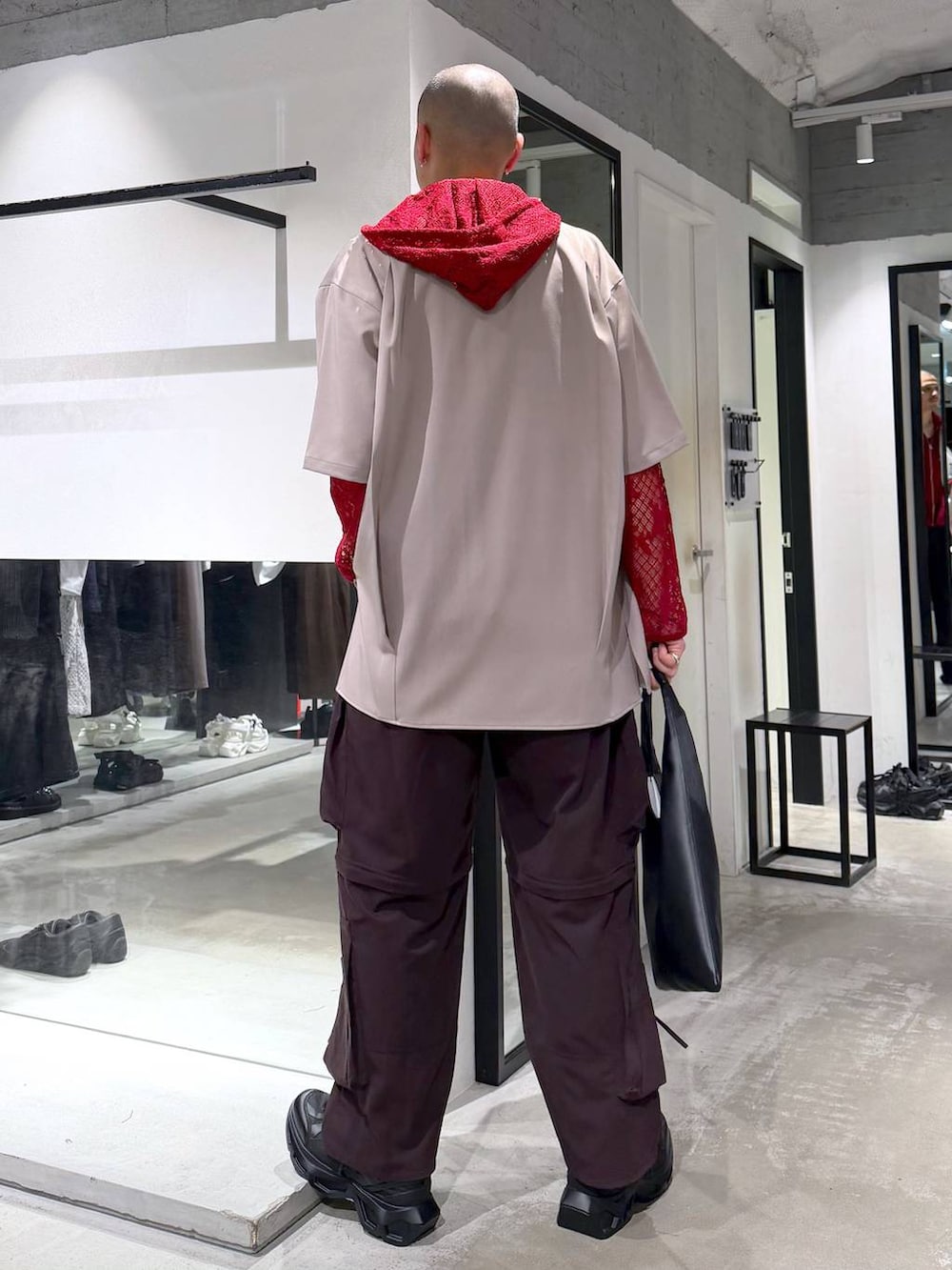 ブラック系のトートバッグ、ブラック系のスニーカー、ブラウン系のカーゴパンツを着用したメンズの春コーディネートの3枚目の写真