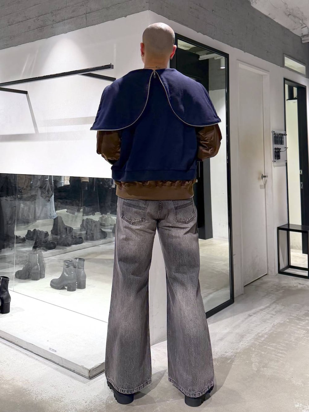 ブラック系のトートバッグ、ブラウン系のデニムパンツ、ブラック系のドレスシューズを着用したメンズの冬コーディネートの5枚目の写真