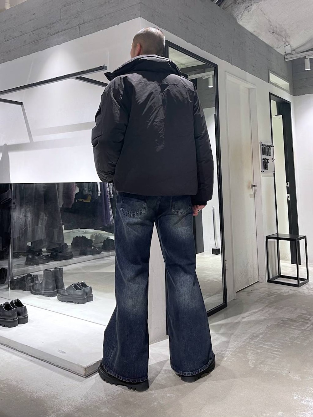 ブラック系のダウンジャケット/コート、ブルー系のデニムパンツ、ブラック系のブルゾンを着用したメンズの秋コーディネートの3枚目の写真