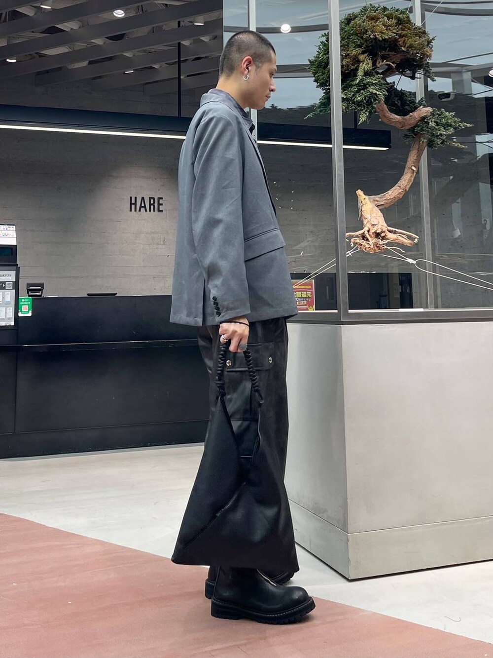 グレー系のカーゴパンツ、グレー系のテーラードジャケット、ブラック系のブーツを着用したメンズの秋コーディネートの4枚目の写真