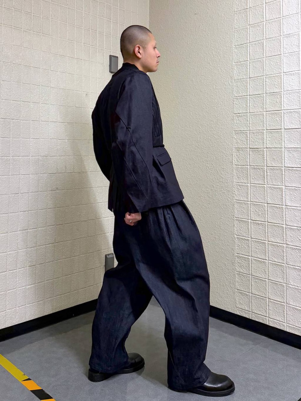 ブルー系のノーカラージャケット、ブルー系のデニムパンツを着用したメンズの春コーディネートの5枚目の写真