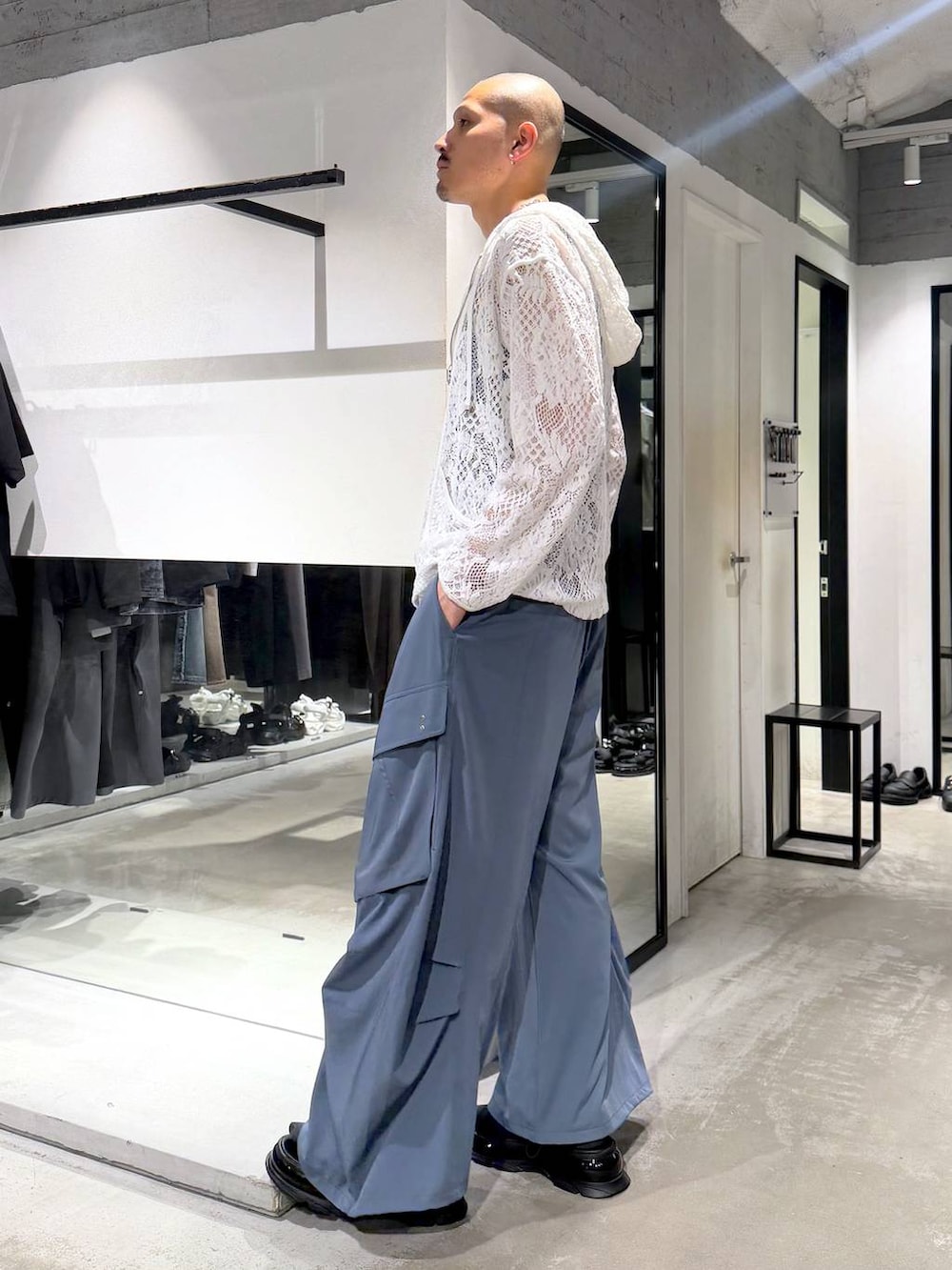 ホワイト系のタンクトップ、ブルー系のカーゴパンツ、ブラック系のサンダルを着用したメンズの夏コーディネートの2枚目の写真