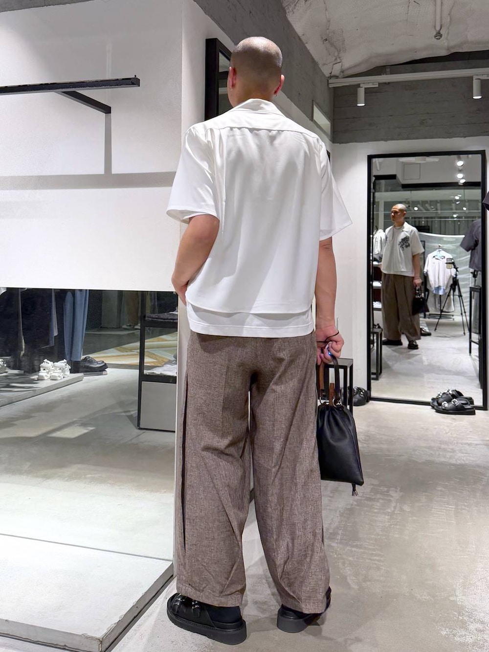 ホワイト系のTシャツ/カットソー、ブラック系のサンダル、ブラック系のショルダーバッグを着用したメンズの夏コーディネートの3枚目の写真