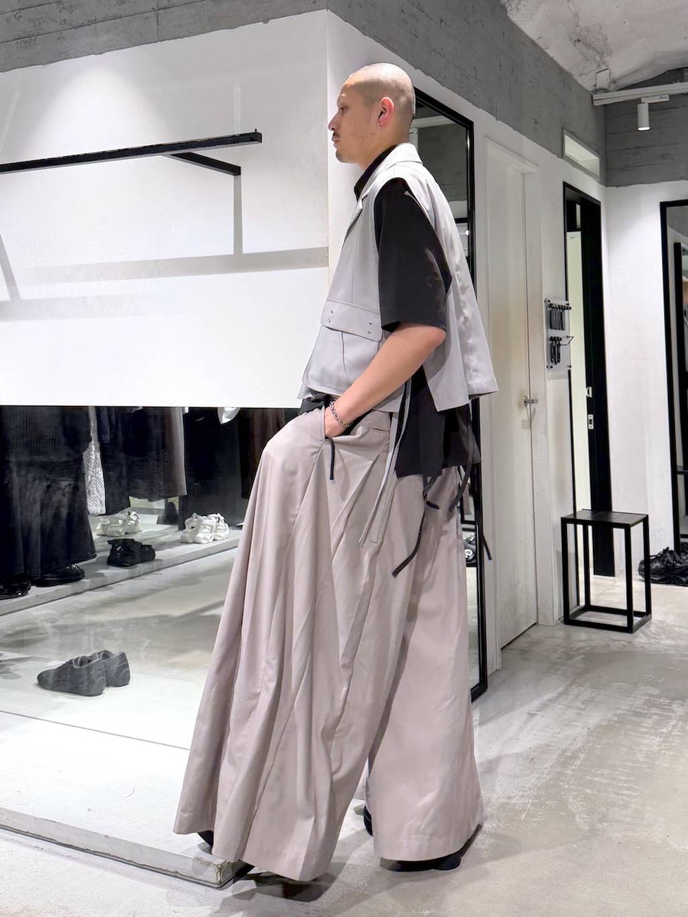 ブラック系のドレスシューズ、グレー系のベスト、ベージュ系のスラックスを着用したメンズの夏コーディネートの3枚目の写真