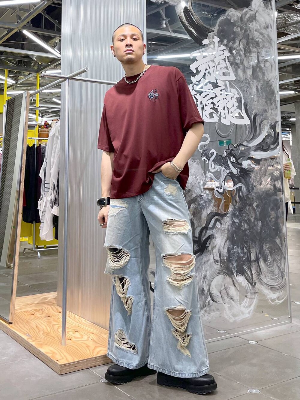 ブラウン系のTシャツ/カットソー、ブルー系のデニムパンツ、ブラック系のドレスシューズを着用したメンズの夏コーディネートの2枚目の写真