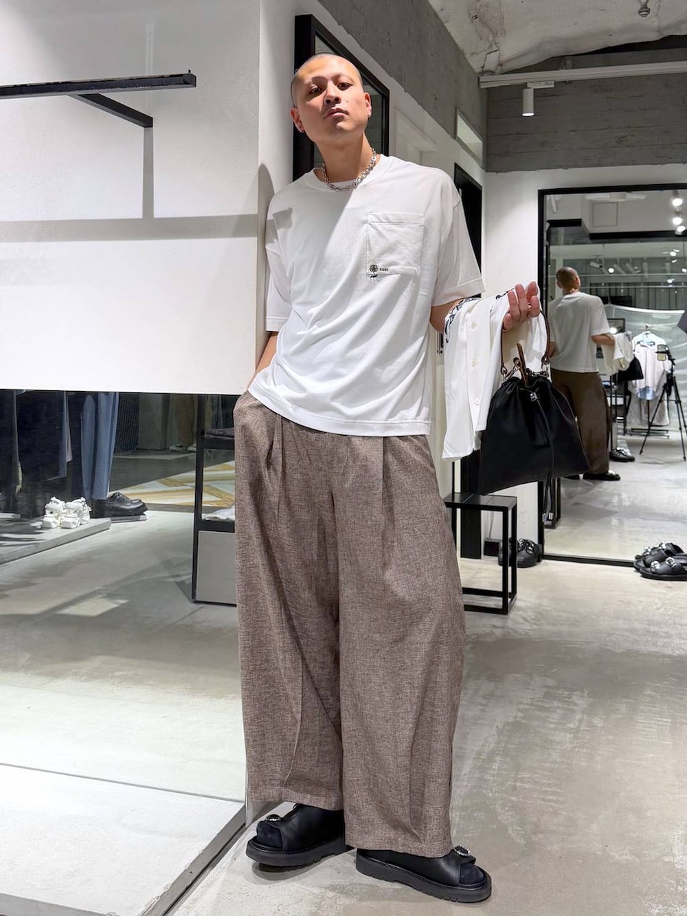 ホワイト系のTシャツ/カットソー、ブラック系のサンダル、ブラック系のショルダーバッグを着用したメンズの夏コーディネートの5枚目の写真