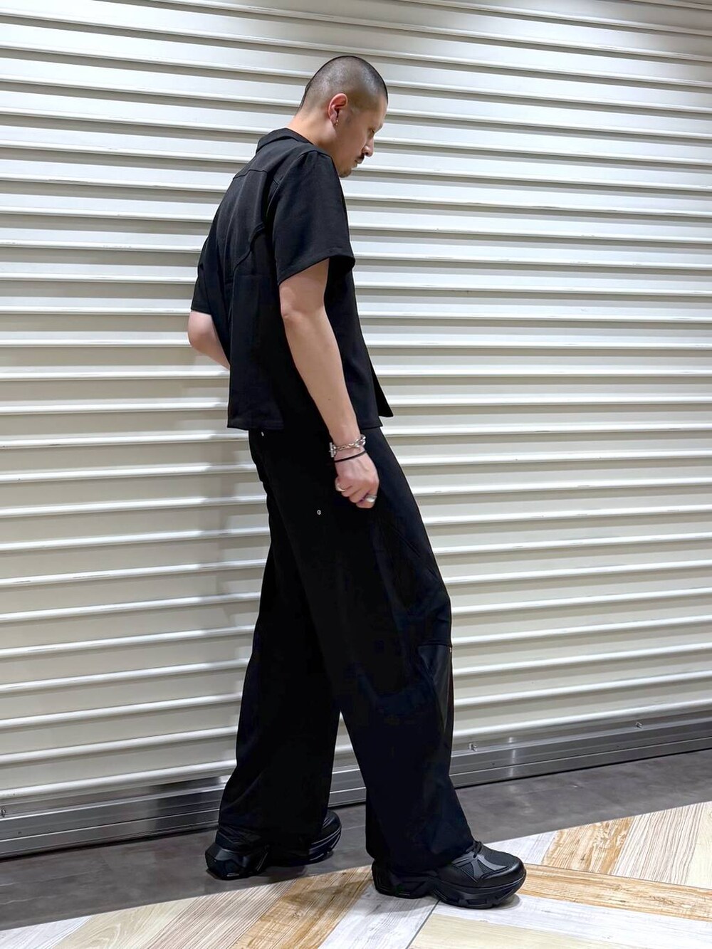 ブラック系のスラックス、ブラック系のシャツ/ブラウス、ブラック系のスニーカーを着用したメンズの夏コーディネートの4枚目の写真