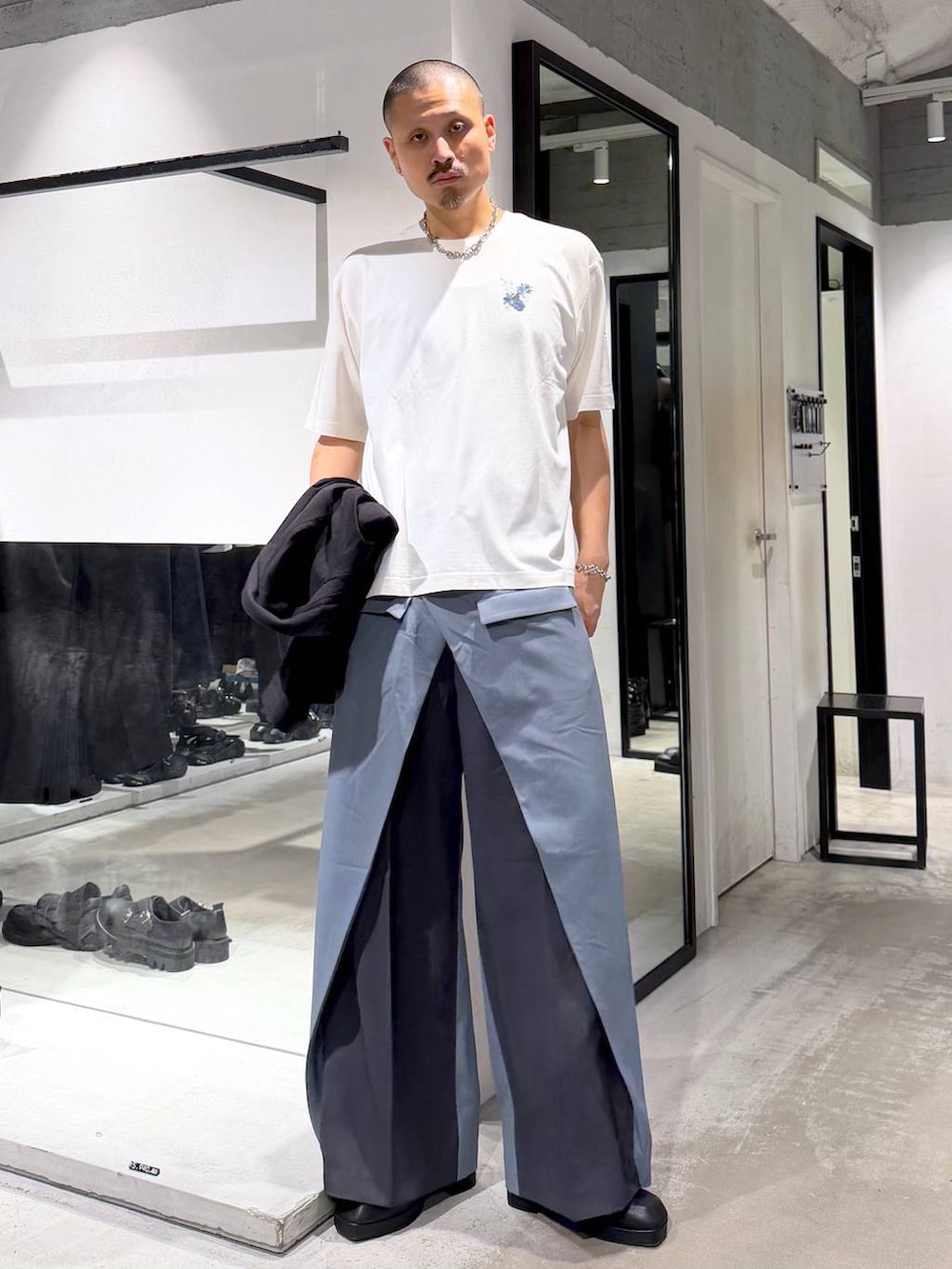 ブラック系のサンダル、ブルー系のスラックス、ホワイト系のTシャツ/カットソーを着用したメンズの夏コーディネートの5枚目の写真