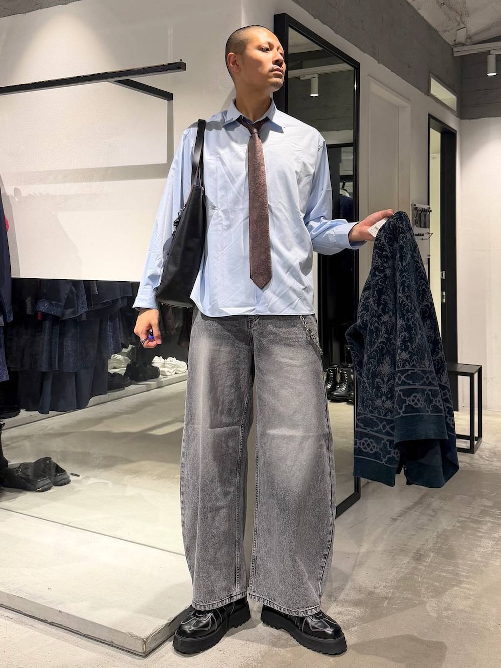 ブラック系のローファー、グレー系のデニムパンツ、ブラウン系のネクタイを着用したメンズの秋コーディネートの5枚目の写真