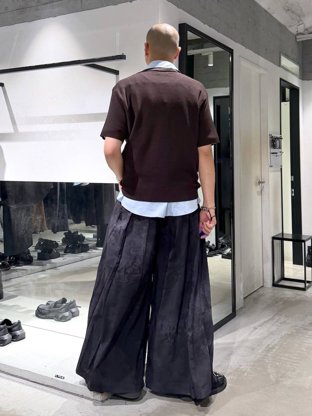 ブラック系のサンダル、ブラウン系のポロシャツ、グレー系のスラックスを着用したメンズの夏コーディネートの3枚目の写真