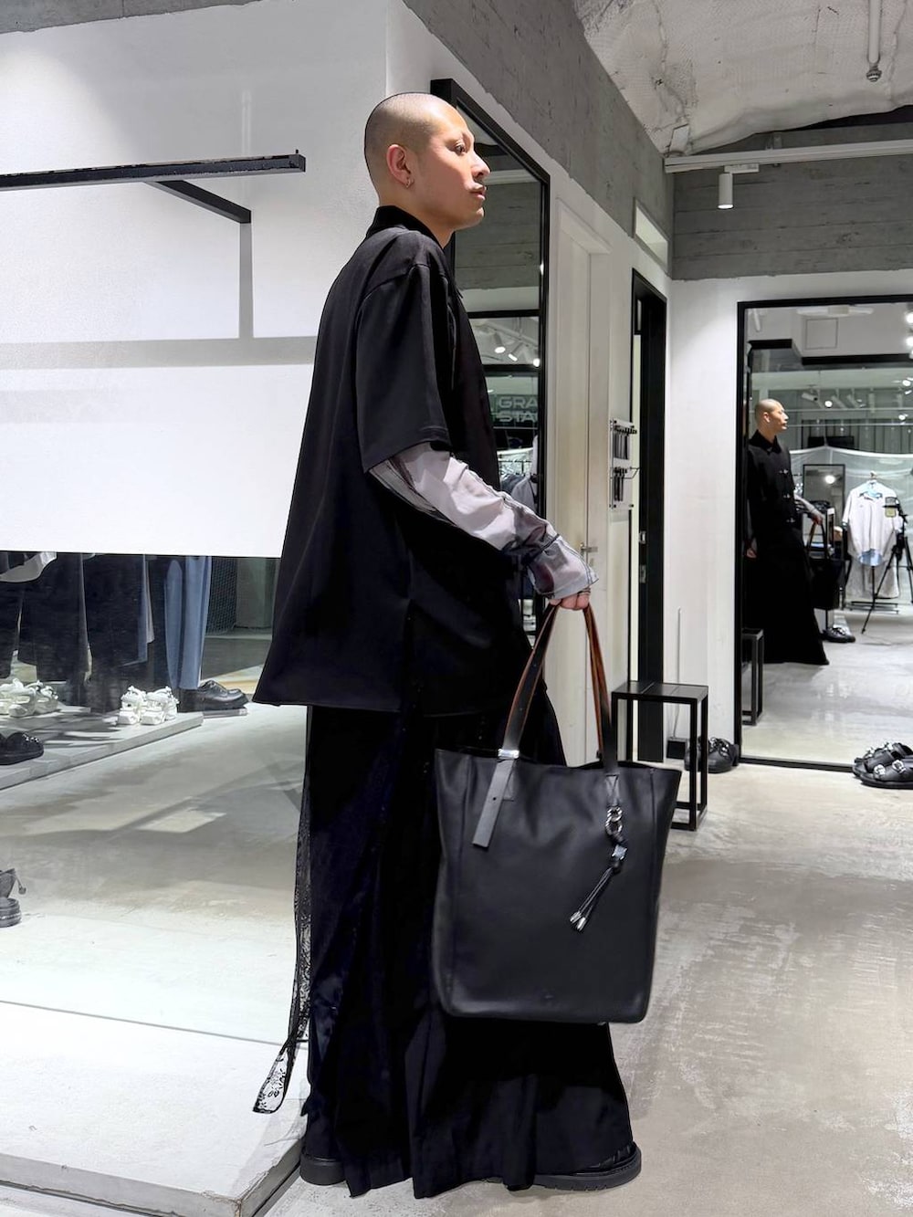 ブラック系のサンダル、ブラック系のトートバッグ、ブラック系のスラックスを着用したメンズの春コーディネートの5枚目の写真