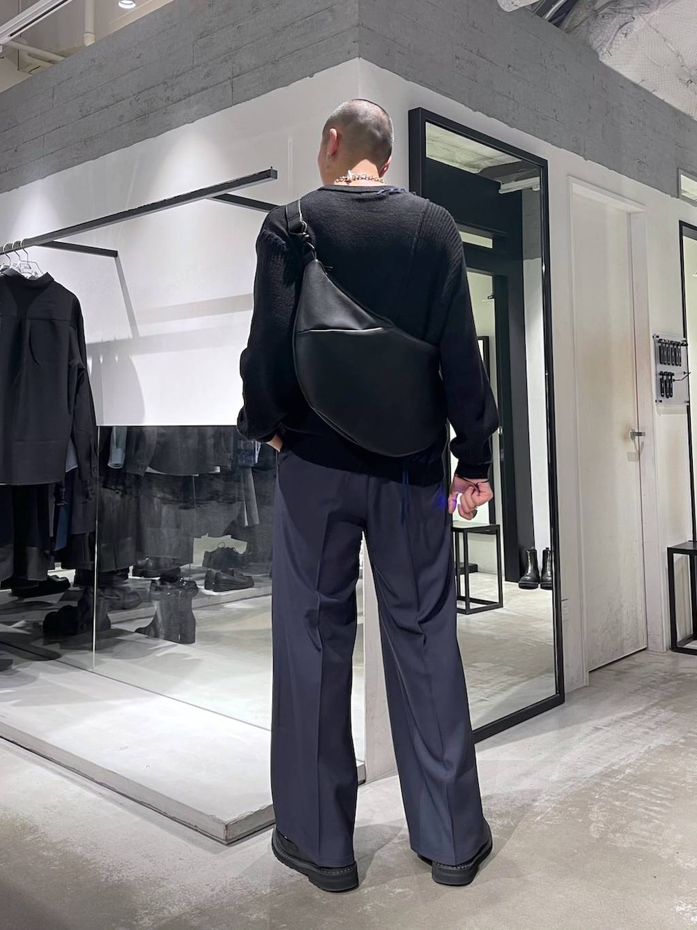 ブラック系のダウンジャケット/コート、ブラック系のブーツ、ブラック系のショルダーバッグを着用したメンズの冬コーディネートの6枚目の写真