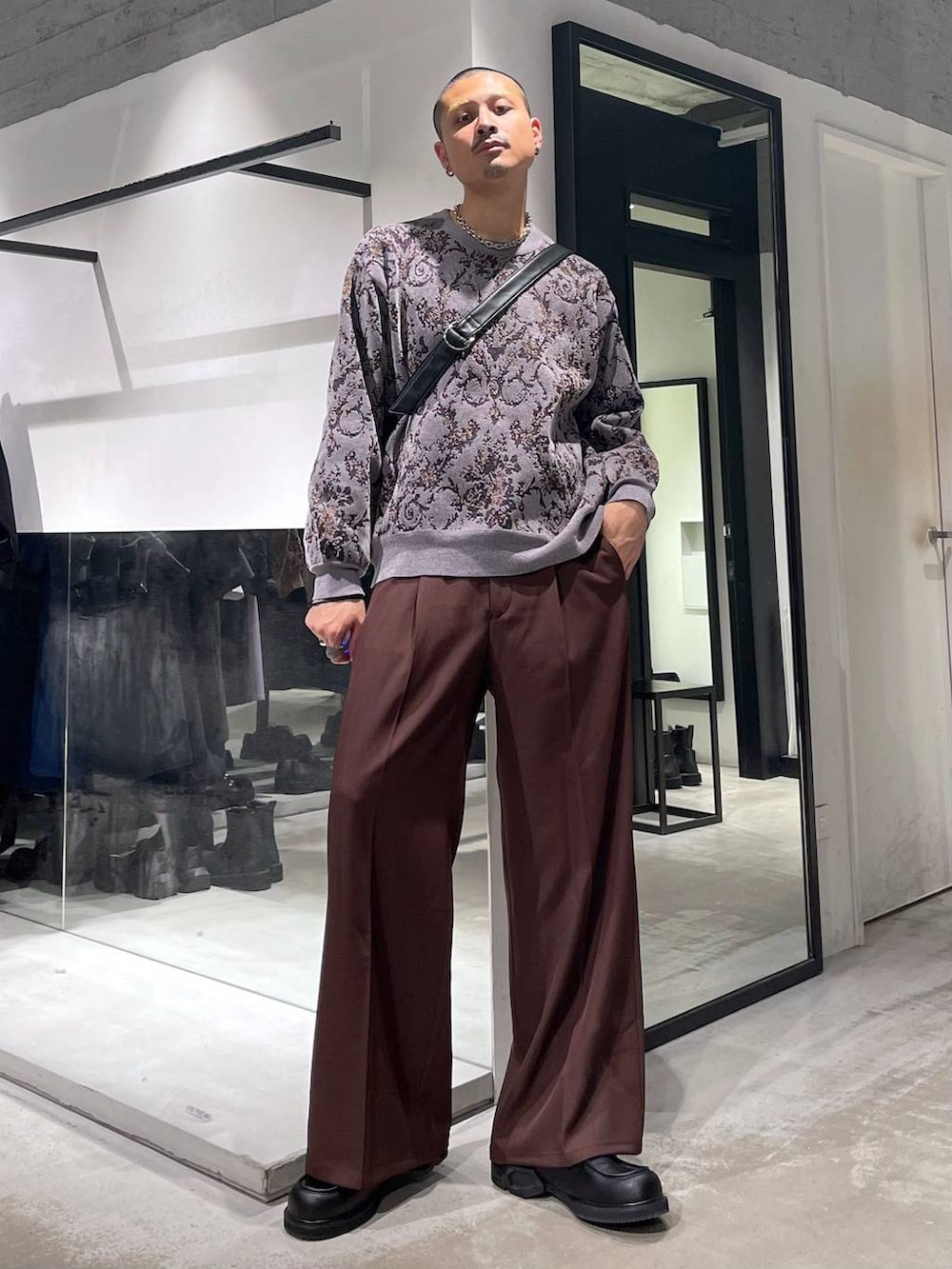 グレー系のニット/セーター、ブラック系のダウンジャケット/コート、レッド系のスラックスを着用したメンズの冬コーディネートの5枚目の写真