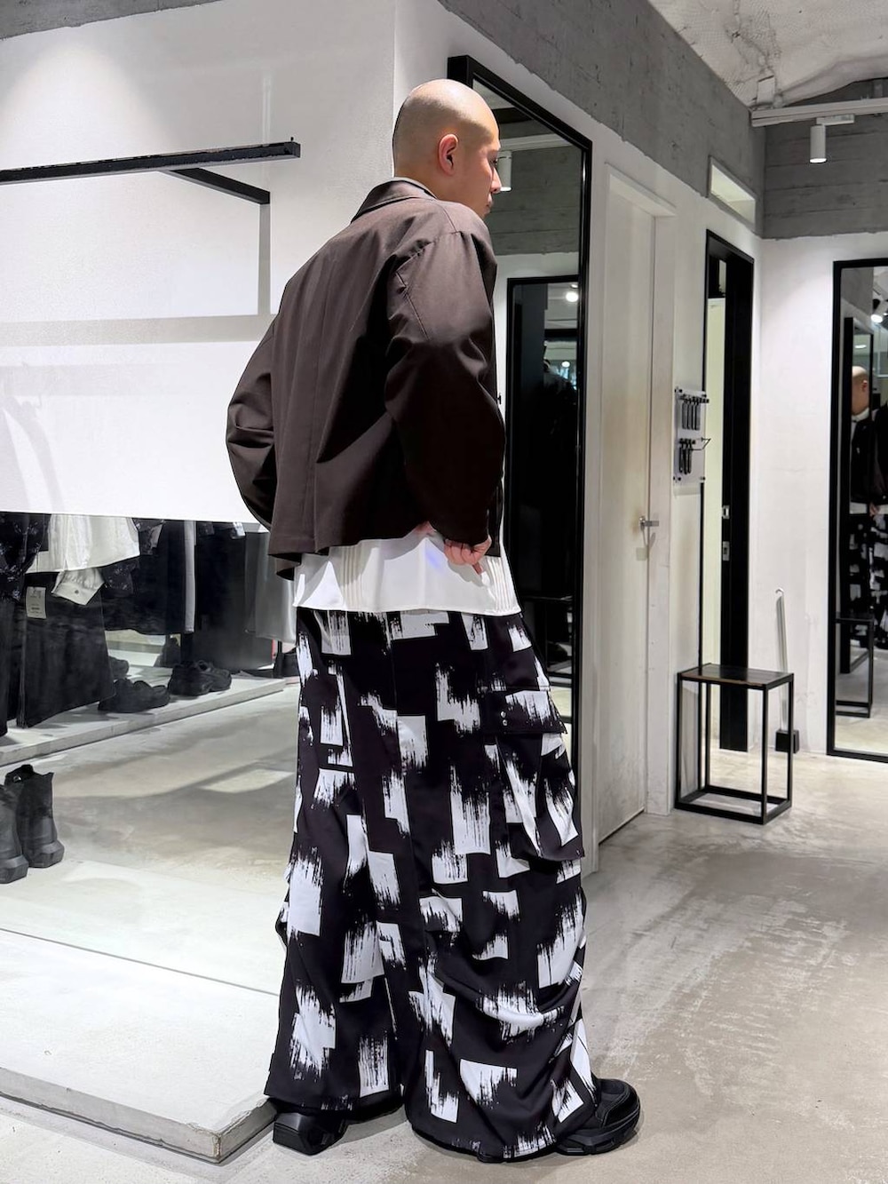 ブラック系のスニーカー、ホワイト系のシャツ/ブラウス、ブラウン系のブルゾンを着用したメンズの春コーディネートの4枚目の写真