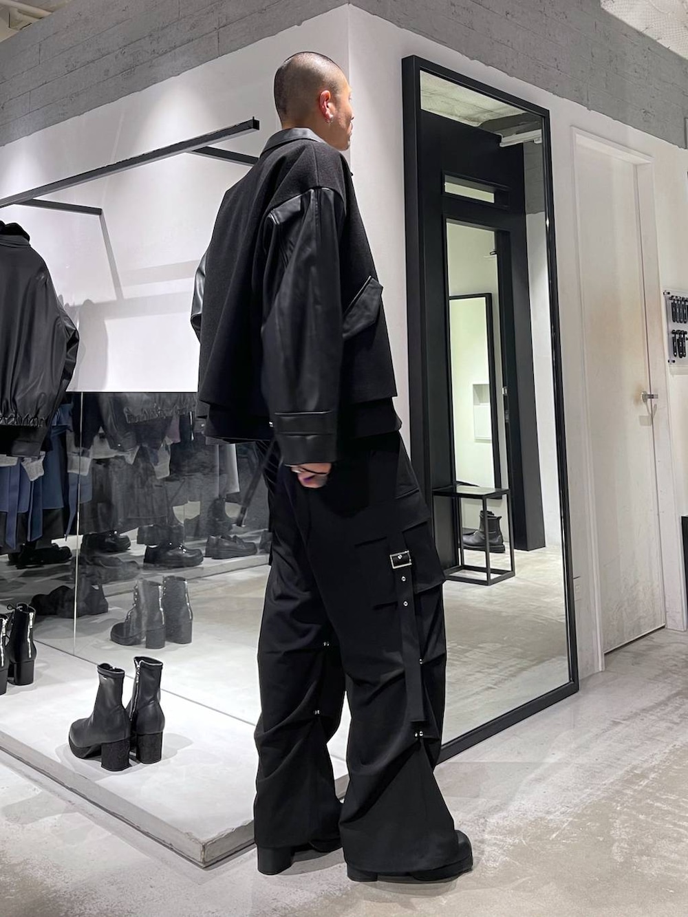 ブラック系のブルゾン、ブラック系のブーツ、ブラック系のカーゴパンツを着用したメンズの冬コーディネートの4枚目の写真