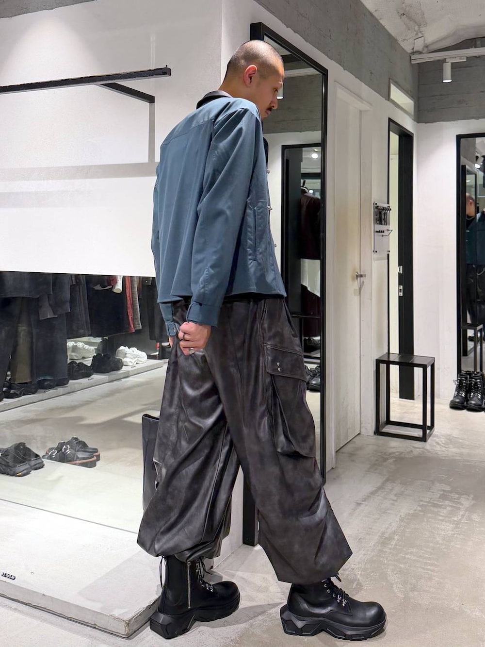 グリーン系のシャツ/ブラウス、ブラック系のブーツ、ブラック系のTシャツ/カットソーを着用したメンズの秋コーディネートの4枚目の写真