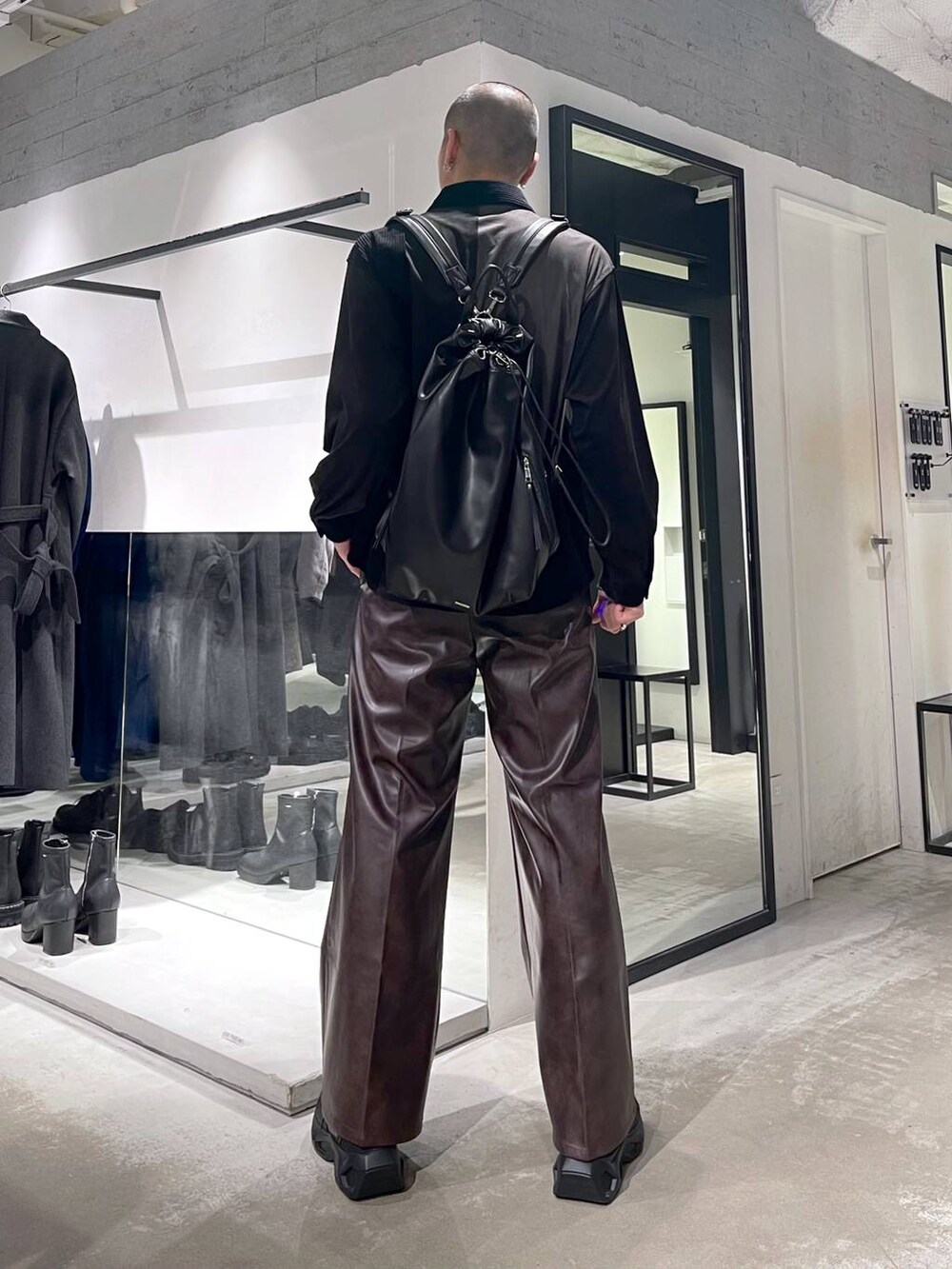レッド系のブルゾン、ブラウン系のスラックス、ブラック系のスニーカーを着用したメンズの冬コーディネートの6枚目の写真
