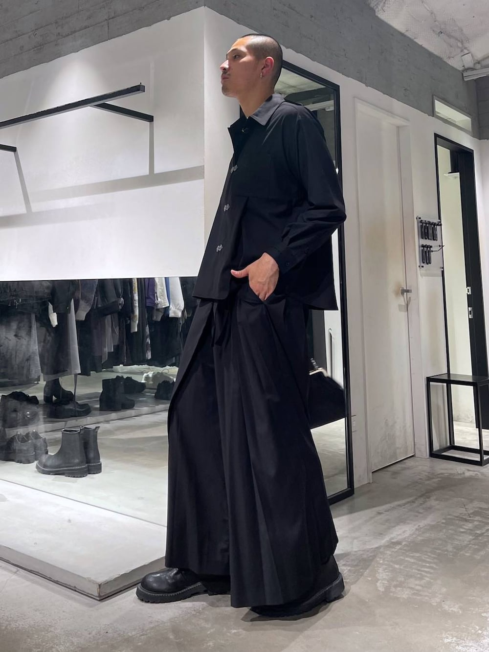 ブラック系のショルダーバッグ、ブラック系のブーツ、ブラック系のスラックスを着用したメンズの秋コーディネートの2枚目の写真