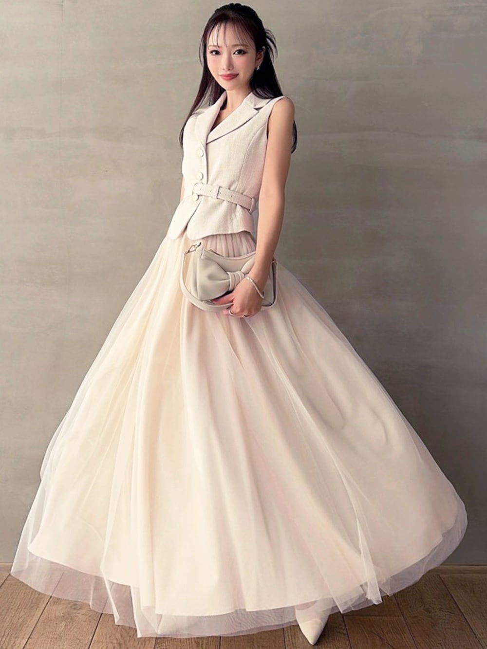 ホワイト系のワンピース、ホワイト系のパンプス、ホワイト系のハンドバッグを着用したレディースの春コーディネートの4枚目の写真