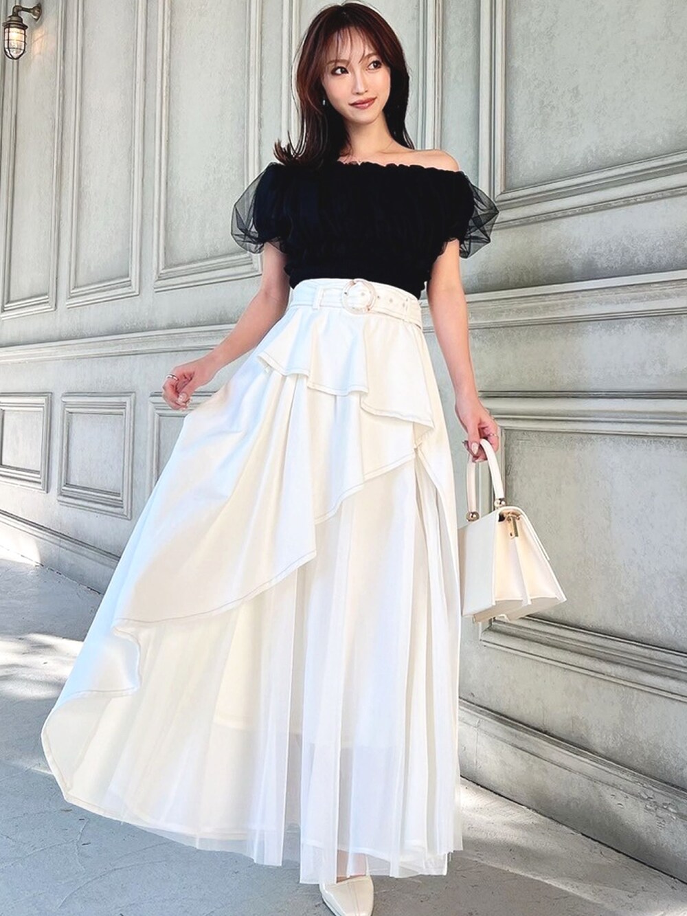 ホワイト系のパンプス、ホワイト系のデニムスカート、ブラック系のシャツ/ブラウスを着用したレディースの冬コーディネートの3枚目の写真