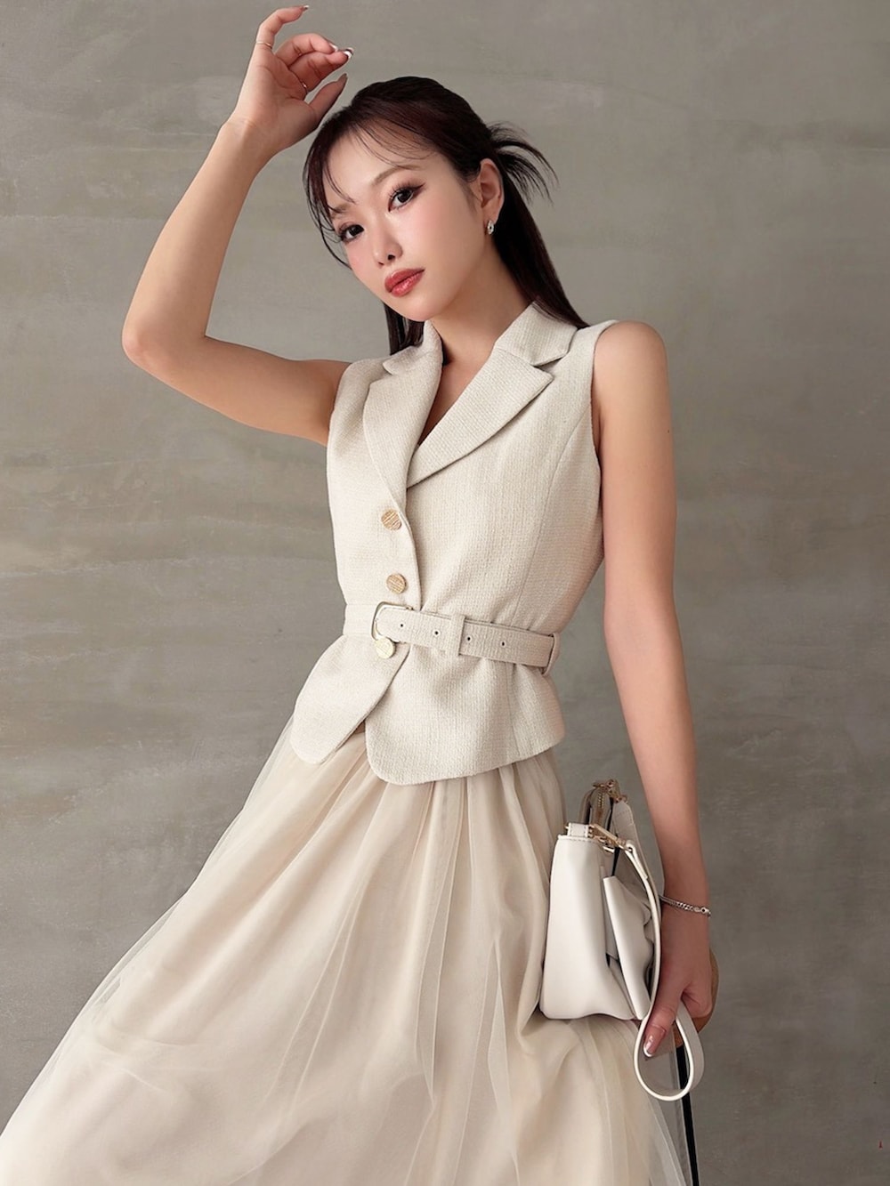 ホワイト系のワンピース、ホワイト系のパンプス、ホワイト系のハンドバッグを着用したレディースの春コーディネートの2枚目の写真