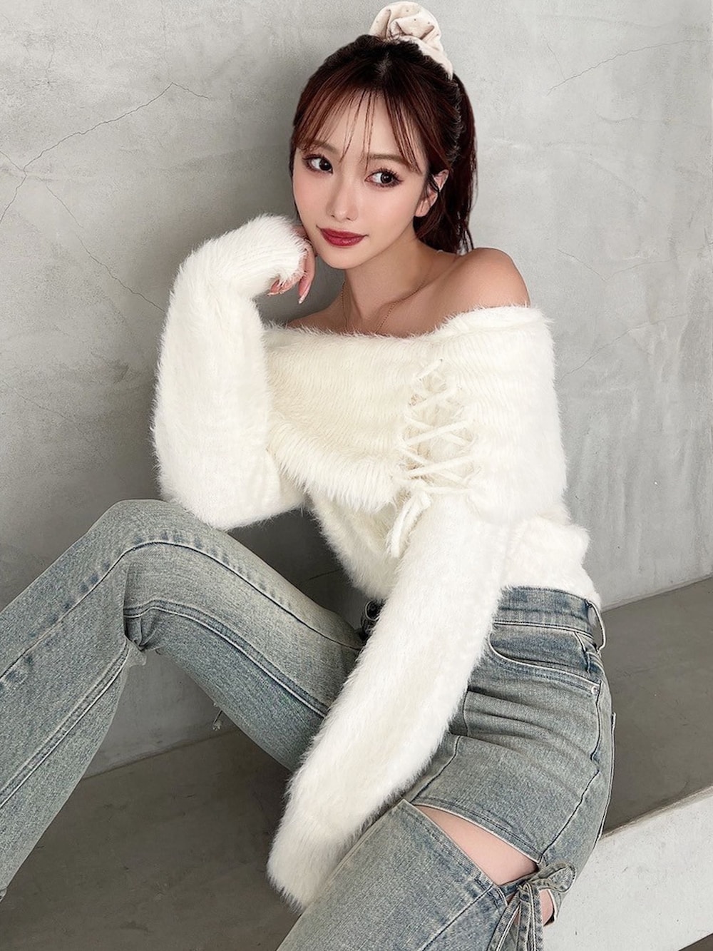 ブルー系のデニムパンツ、ホワイト系のニット/セーターを着用したレディースの秋コーディネートの4枚目の写真