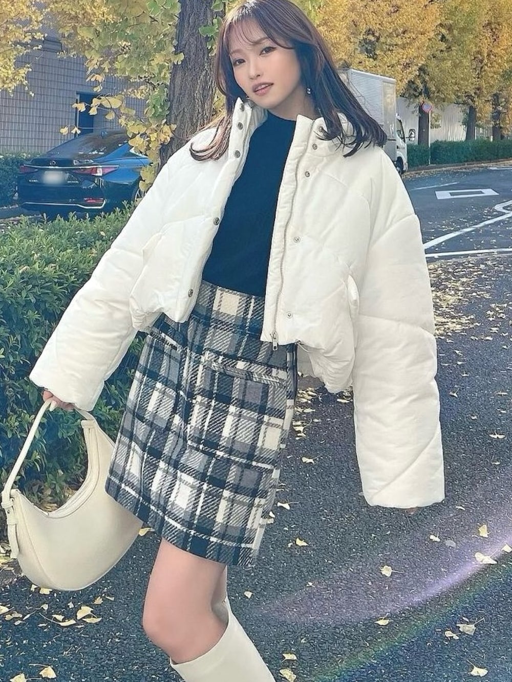 ホワイト系のブルゾン、ホワイト系のブーツ、その他のスカートを着用したレディースの冬コーディネートの2枚目の写真